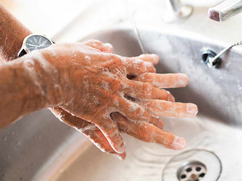 a person washing their hands in soapy water