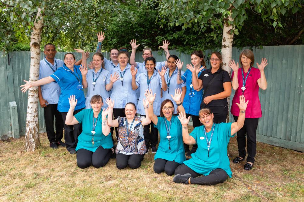 Staff-smiling-with-hands-in-the-air